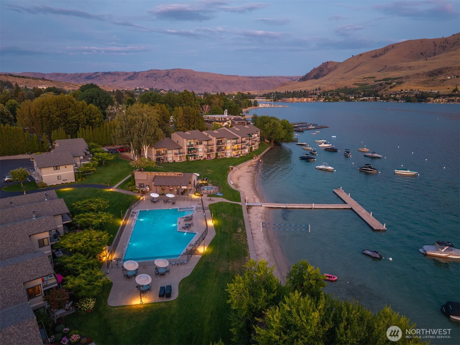 Aerial view of Spader Bay property with Olympic-sized pool, grassy lawn, sandy beach, waterfront, T-dock and mooring buoys.
