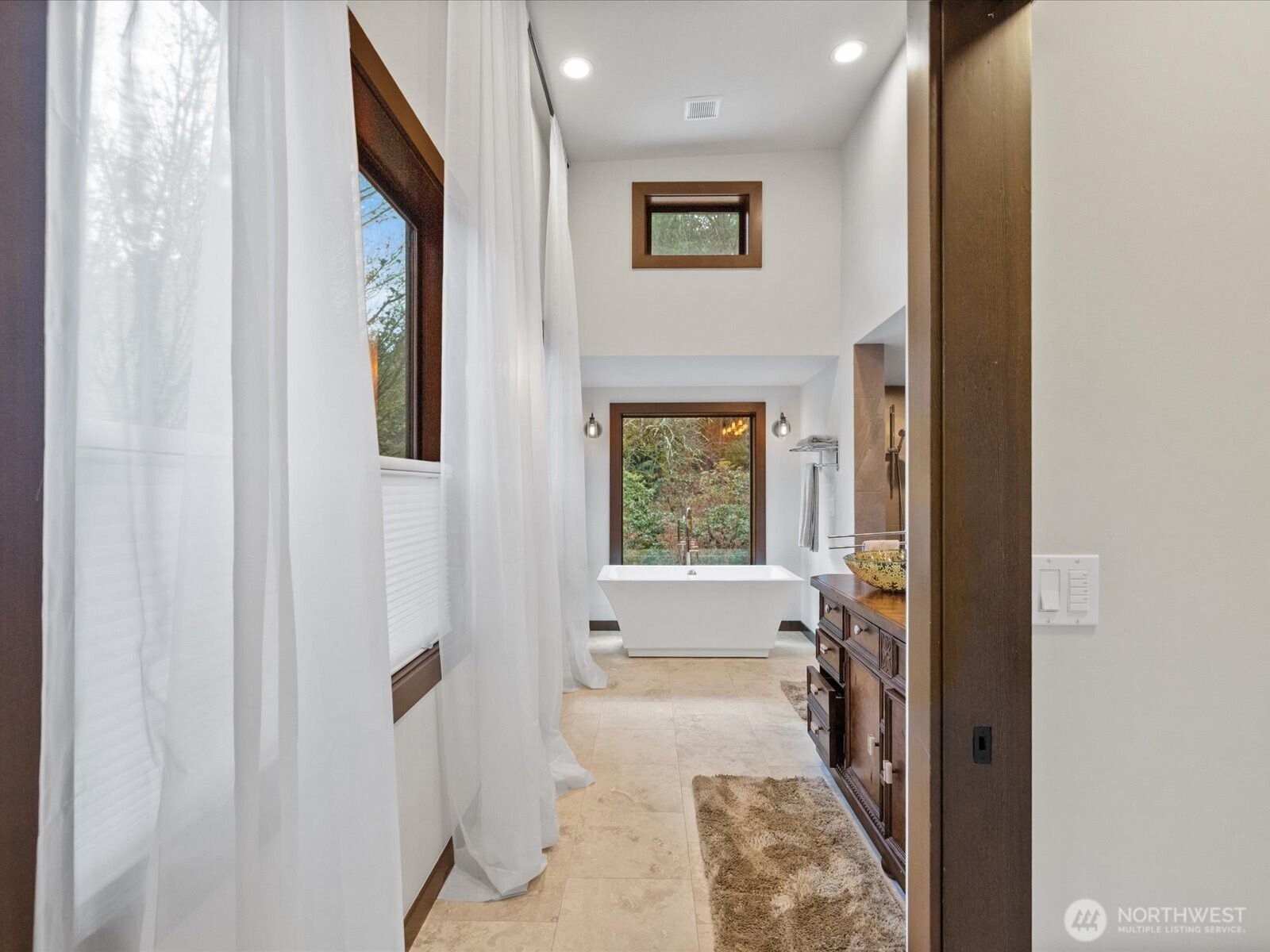 Spa-like primary bath with serene, private outlook into your lush garden from your oversized soaking tub.