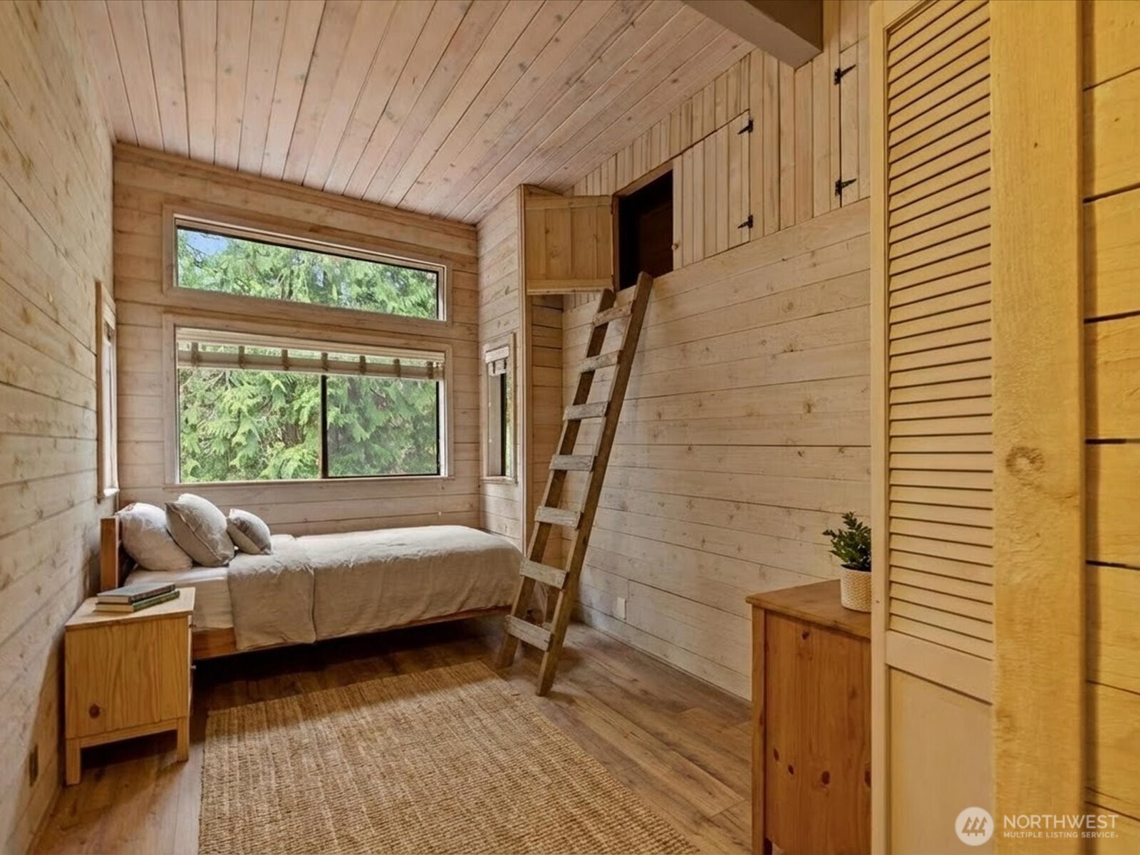 Thoughtfully designed bedroom with efficient use of space with built-in loft storage accessed by custom ladder