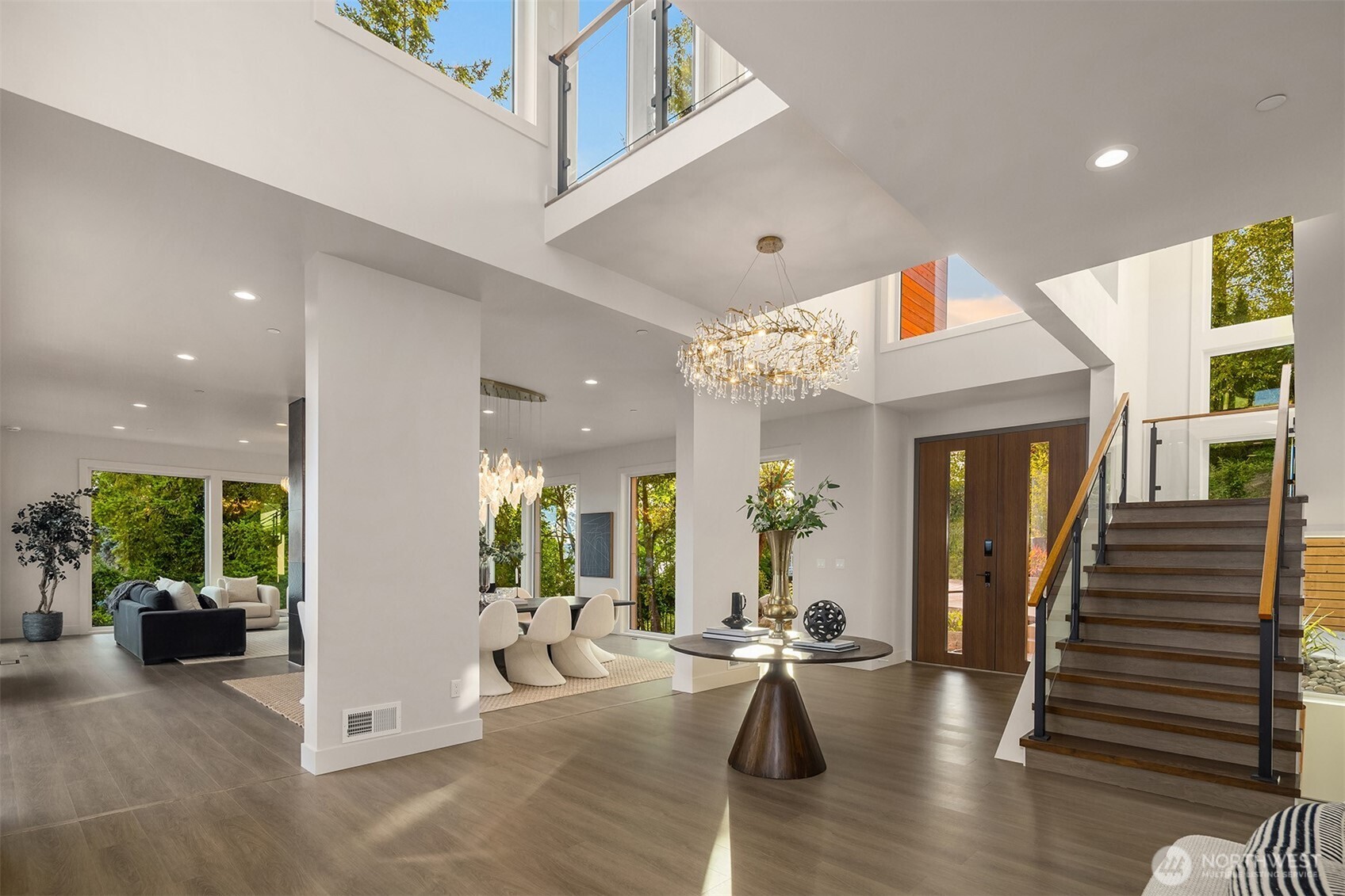 Soaring ceilings, expansive sightlines, and statement lighting define the entry, where modern architecture and natural light create an unforgettable sense of arrival
