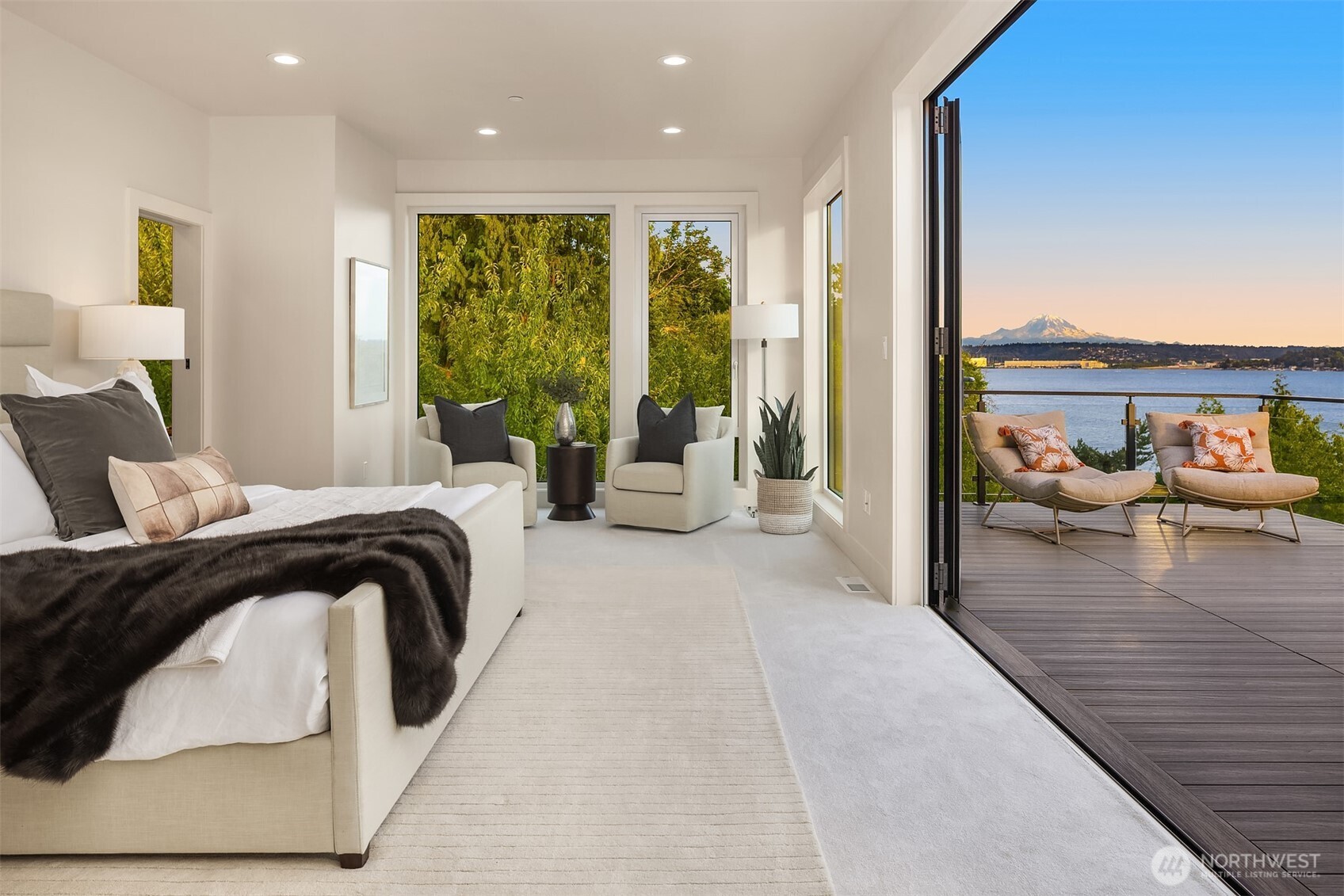 Upper-level primary suite with operable window walls opening to a private deck, blending indoor comfort with panoramic views of Lake Washington and Mount Rainier