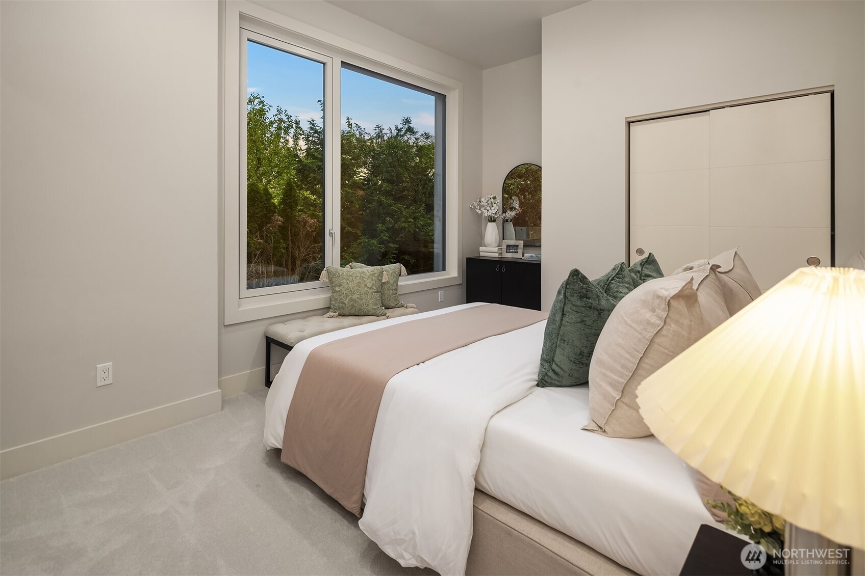 One of four upper-level bedrooms, this serene ensuite offers restful garden views and a calming, sophisticated palette