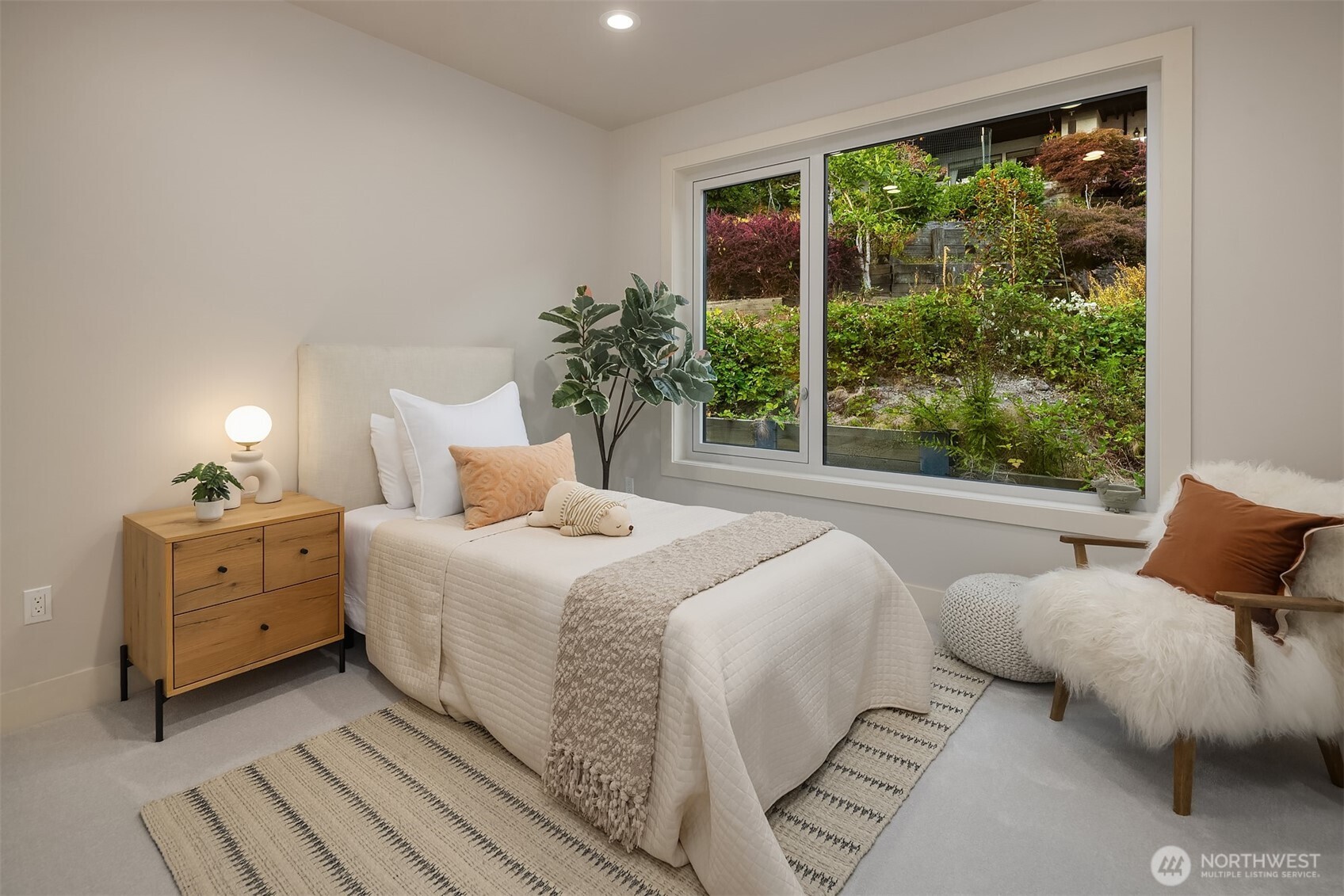 One of four upper-level bedrooms, this serene retreat connects to a Jack-and-Jill full bath and overlooks lush, landscaped gardens