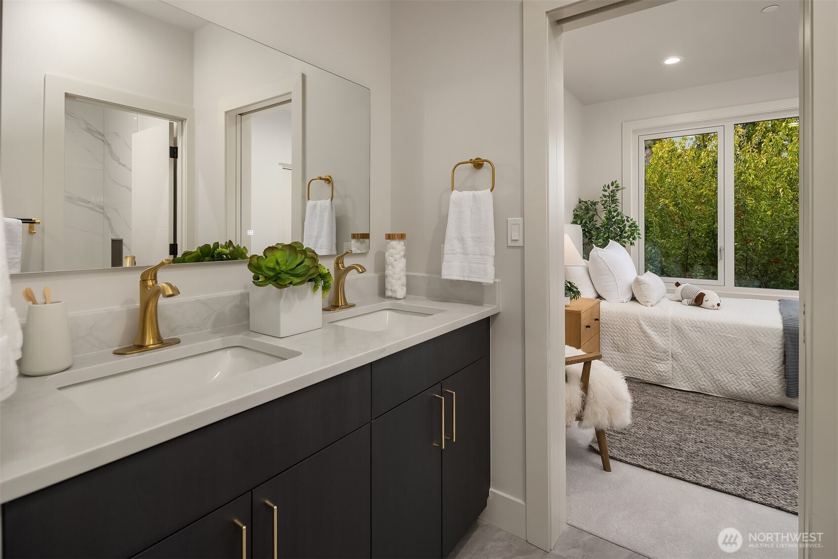 Elegant Jack-and-Jill bathroom with dual sinks, brass fixtures, and a sleek design, seamlessly connecting two upper-level bedrooms