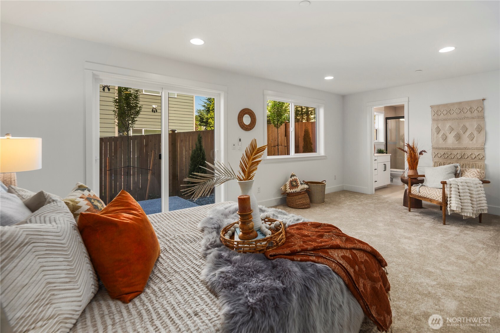 Lower Level Suite: Expansive lower-level suite features plush carpeting, sliding glass doors to the backyard, and large windows that fill the room with natural light. This versatile retreat works beautifully as a private guest suite, multi-generational space, or flexible bonus room.  Staged photos are of the model home of the same floorplan within the Foxmoore community and are for visualization purposes only. Colors, finishes, and layout can and will vary.