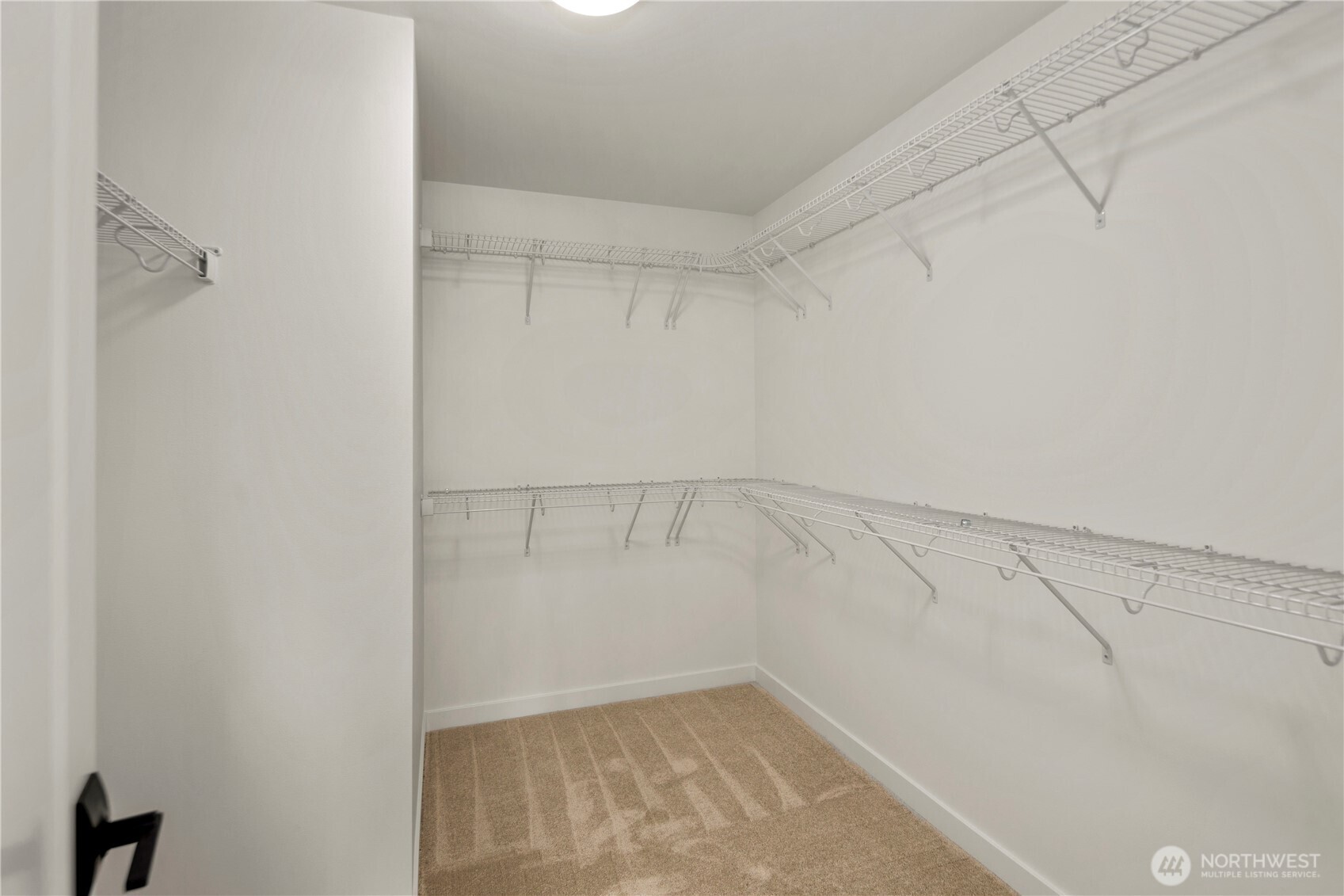 Primary Walk-In Closet: An expansive walk-in closet provides abundant hanging space and shelving to keep wardrobes organized with ease. Its size and layout allow for flexible storage solutions that fit modern lifestyles.  Staged photos are of the model home of the same floorplan within the Foxmoore community and are for visualization purposes only. Colors, finishes, and layout can and will vary.