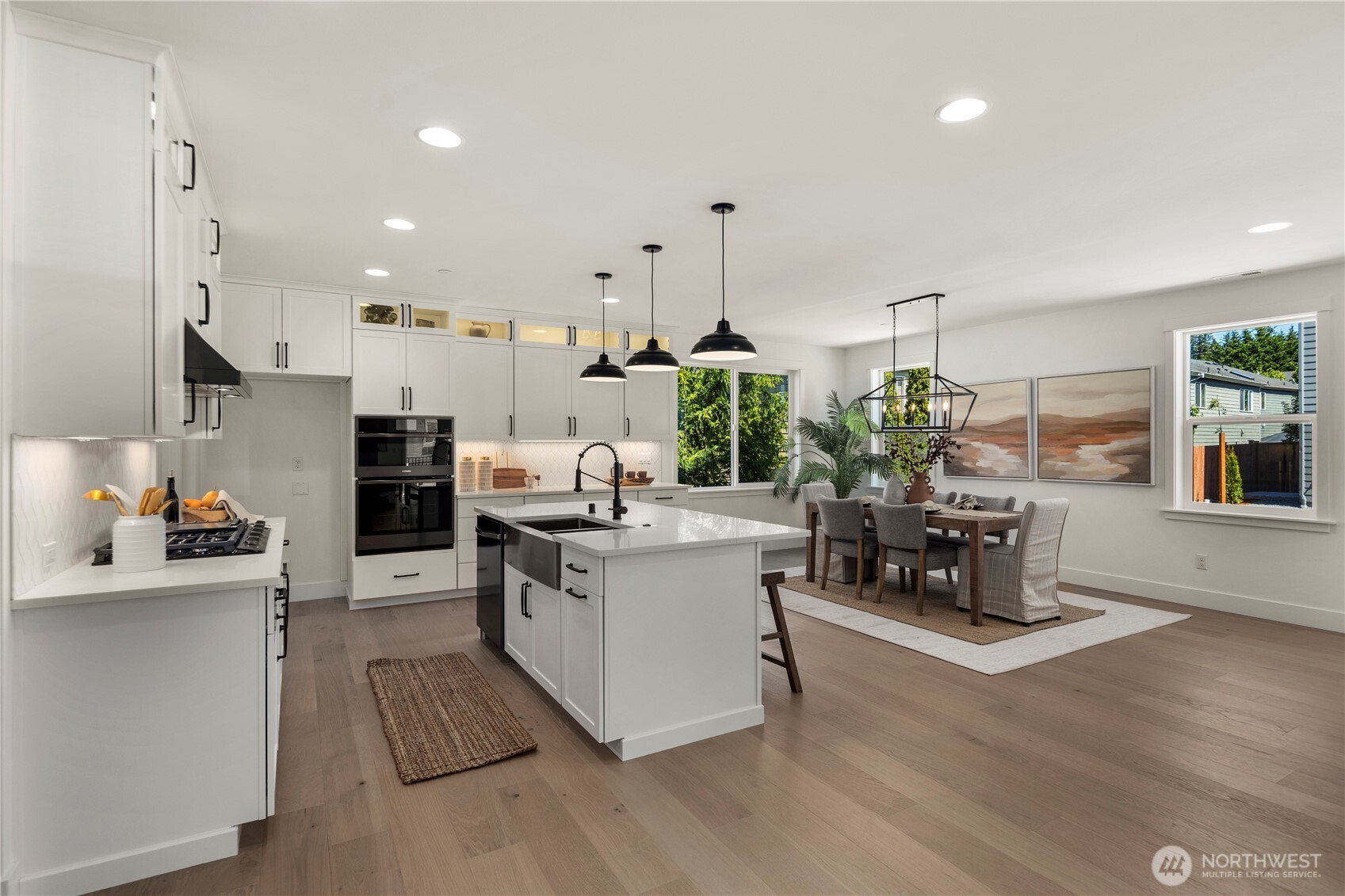 Kitchen & Dining Angle Two: Crisp white cabinetry, built-in double ovens, and stylish lighting give this kitchen a timeless appeal. Positioned next to the dining nook, it’s designed for effortless meals and hosting gatherings.  Staged photos are of the model home of the same floorplan within the Foxmoore community and are for visualization purposes only. Colors, finishes, and layout can and will vary.