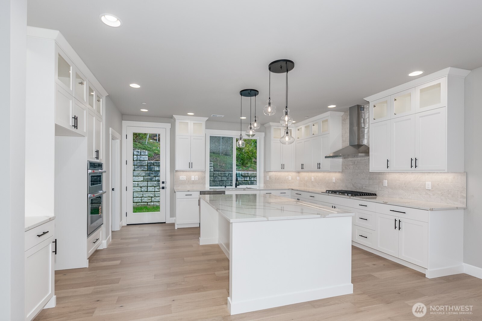The huge gourmet kitchen features custom cabinets with upper glass detail and an abundance of counter space.