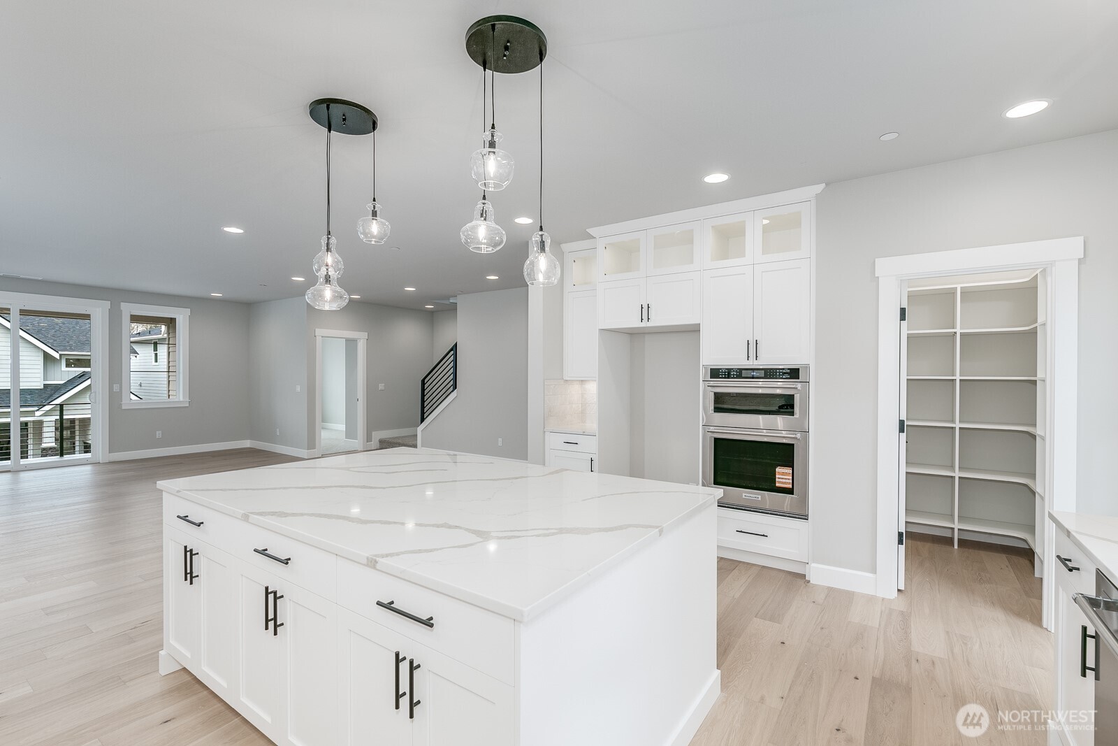 The Great Room with oversized tile fireplace leads to a large, covered deck for relaxing in all seasons.   Extensive white millwork wraps every window throughout the home.