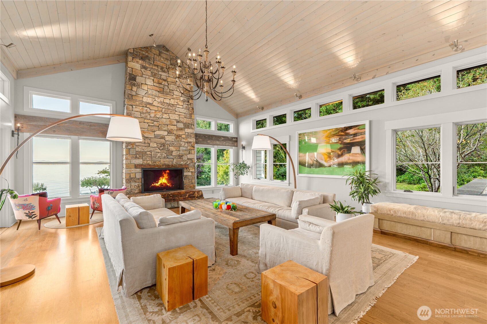 Living room enjoys natural light, Rocky Bay views, built-in seating and the warmth of the wood-burning fireplace