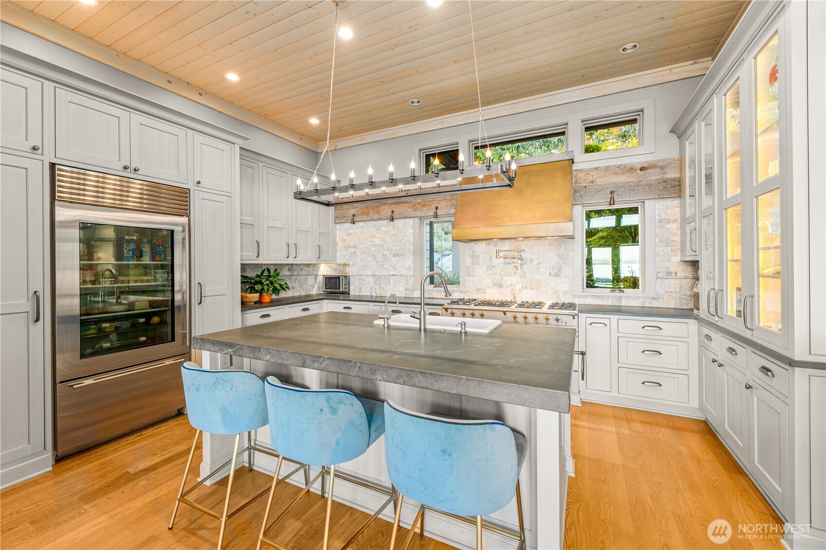 The kitchen features honed Pietra del Cardosp countertops, a 55" LaCanche range and a commercial SubZero refrigerator.
