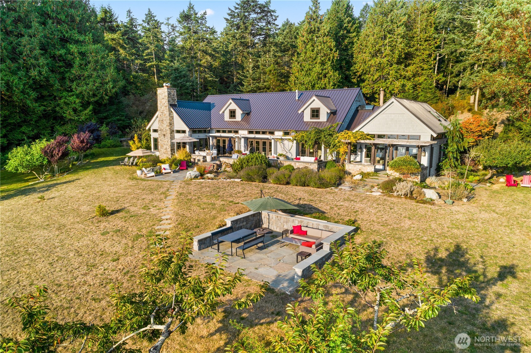 Multiple entertaining patios and sitting areas are found all over this stunning waterfront property. Lower patio in foreground is great for a BBQ, sunset dinners and a natural dance floor.