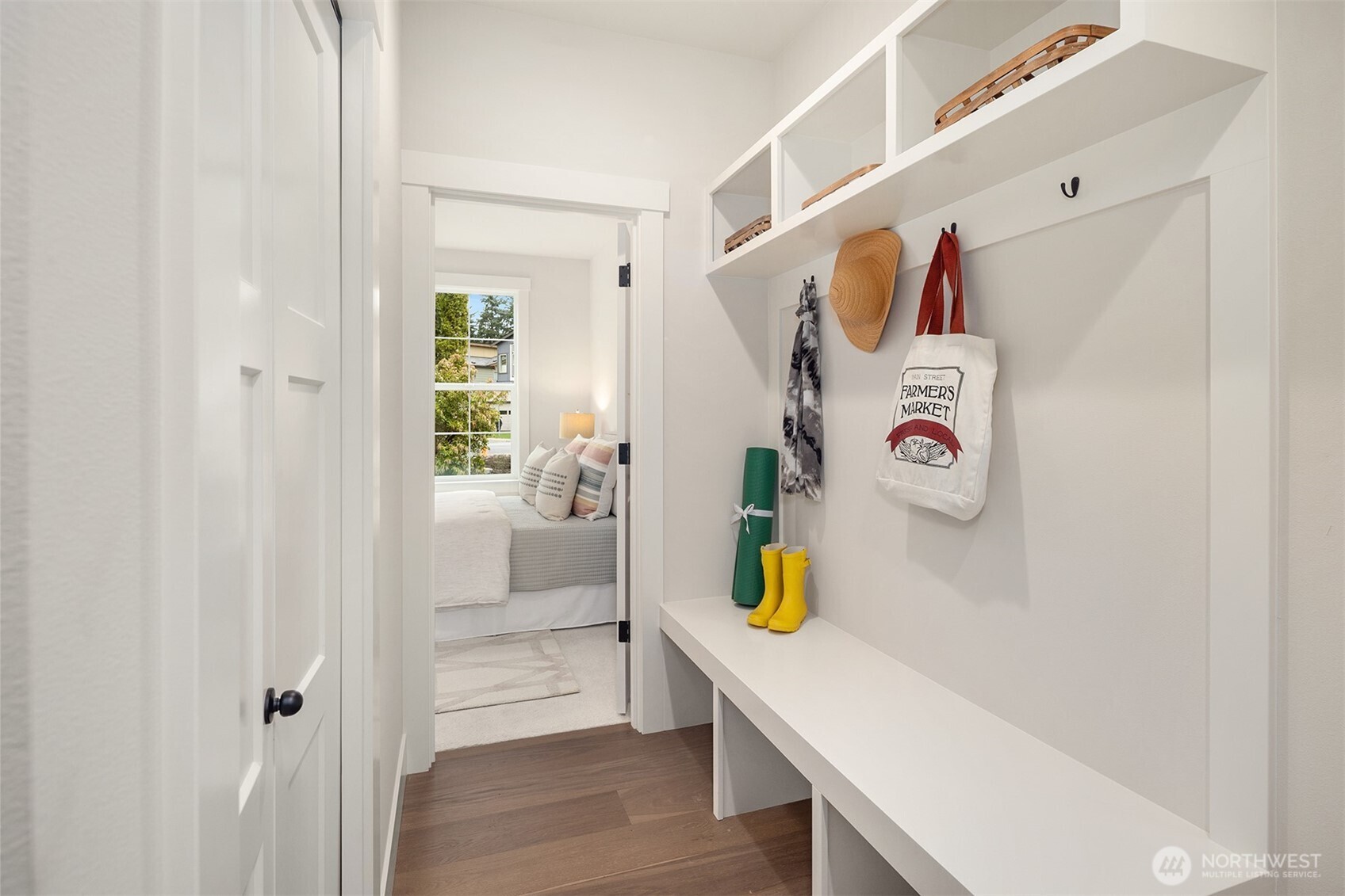 Custom built-in bench with cubbies and coat rack at entry from Garage.