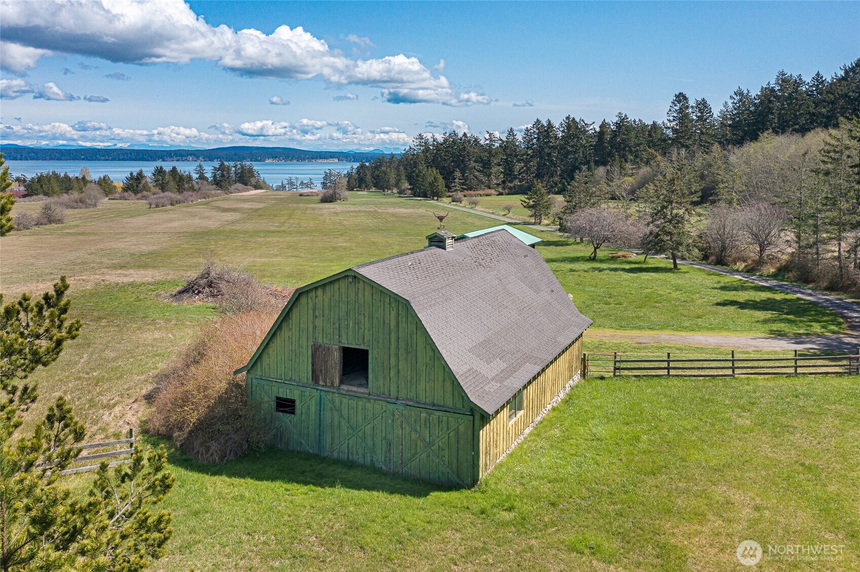 Charming historic barn overlooking the airstrip and San Juan Channel views—ideal for storage, hobbies, or agricultural use within this expansive island property.