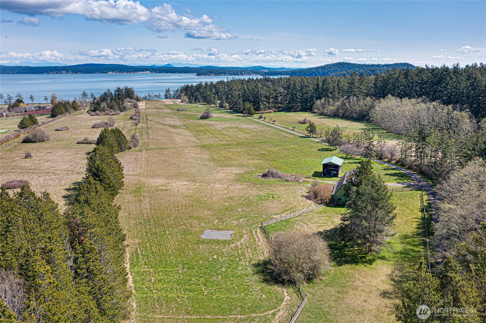 Private 2,400± ft FAA-certified runway bordered by open pasture and mature forest, with historic barn and outbuildings enhancing the estate’s legacy character.