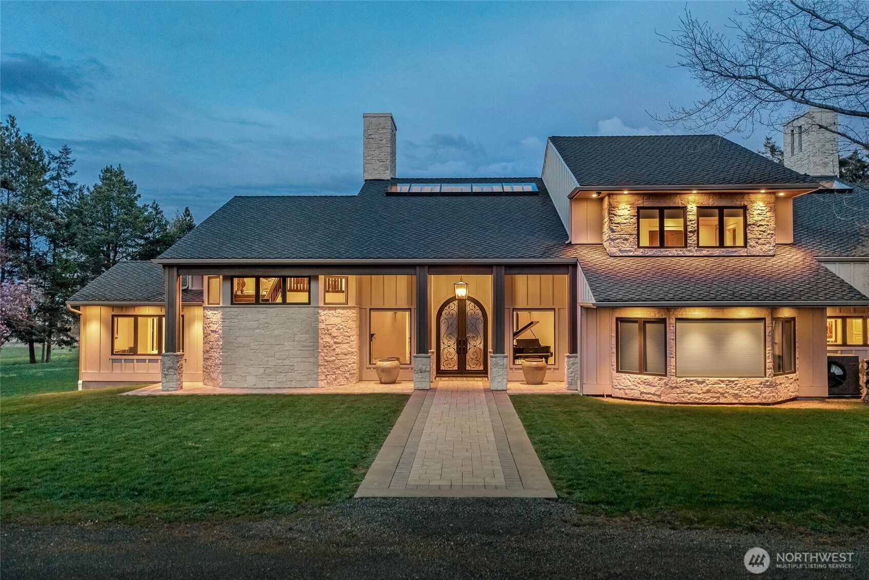 Elegant covered entry featuring custom iron and glass double doors, stone accents, and refined architectural detailing welcoming you into this luxury island residence.