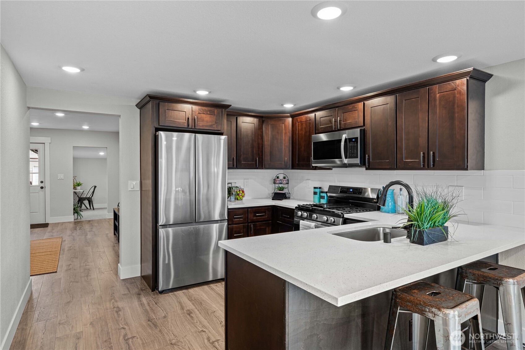 Amazing Kitchen w/Stainless Appliances, New Cabinets, Gleaming White Quartz Counters and Tile Backsplash.