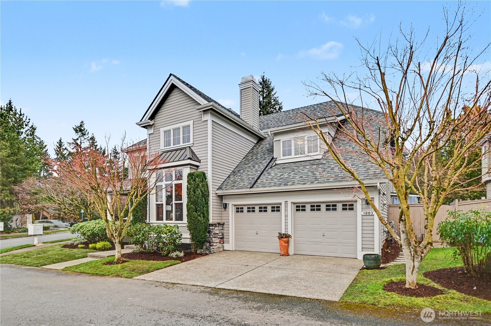 Striking curb appeal with sophisticated gray and white exterior accented by a vibrant red front door and two car garage.