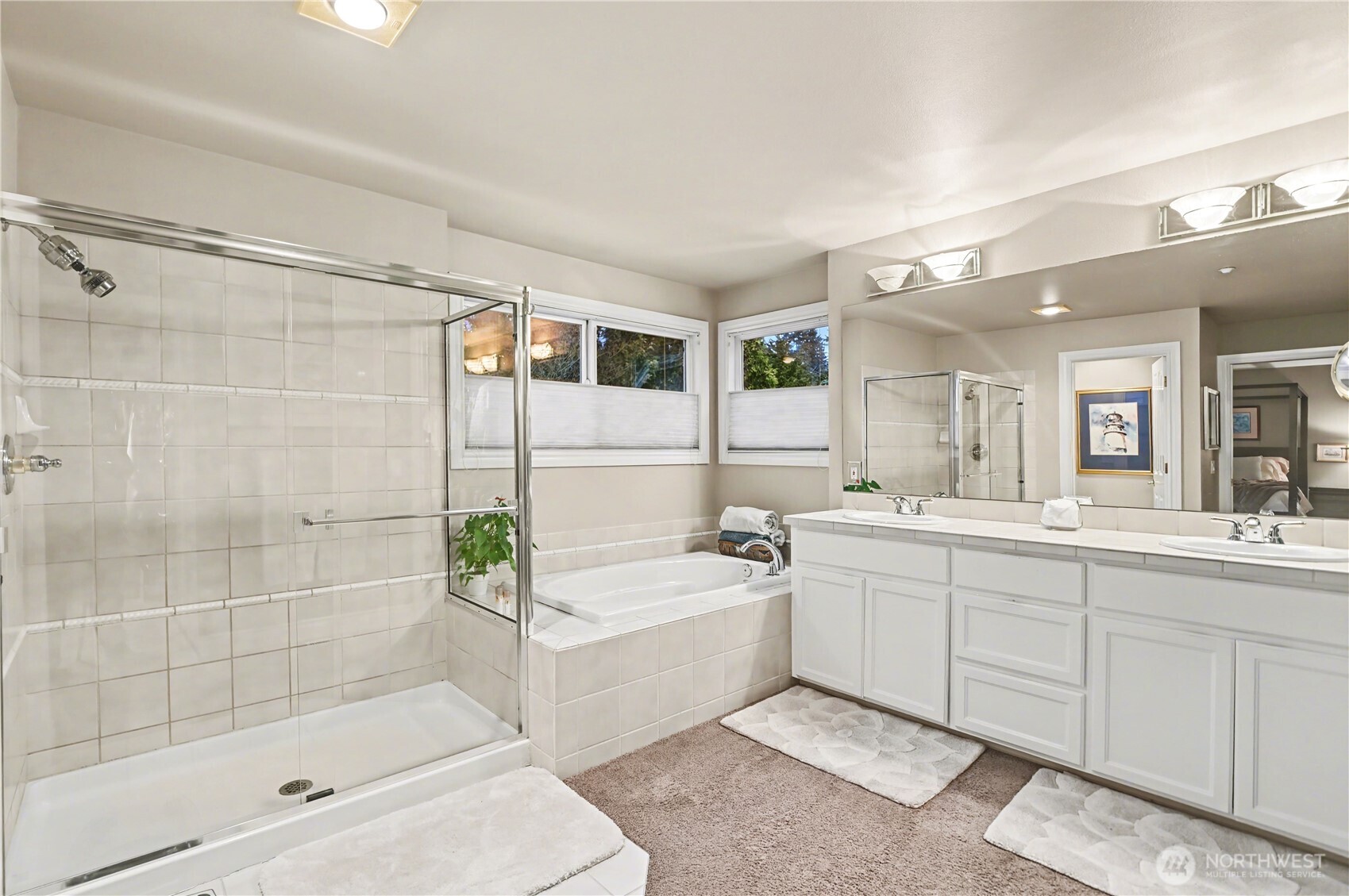 Elegant primary bathroom includes a soaking tub, separate shower, water closet, and dual sinks with generous storage.