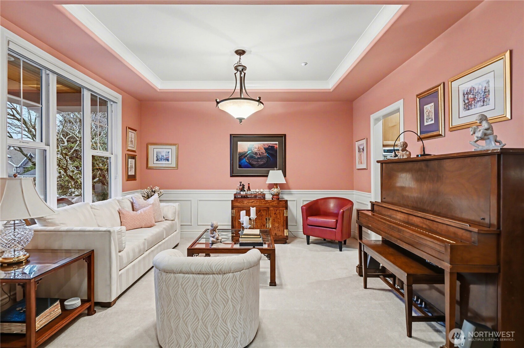 Beautiful architectural details, including tray ceilings and wainscoting, enhance the home’s charm, while expansive windows flood the space with natural light.