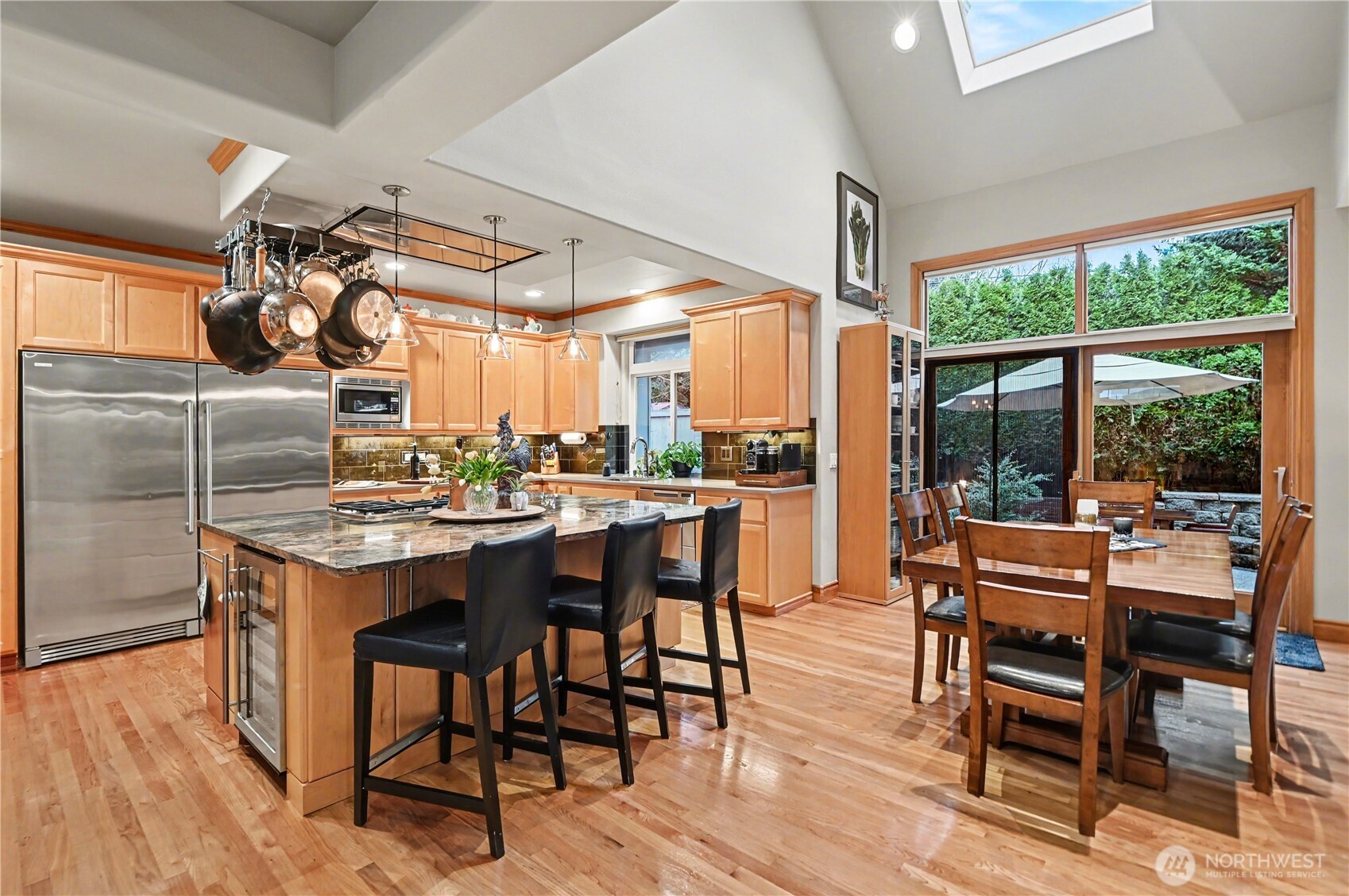 Light-filled chef’s kitchen with vaulted ceilings and skylight creates an inviting central gathering space.