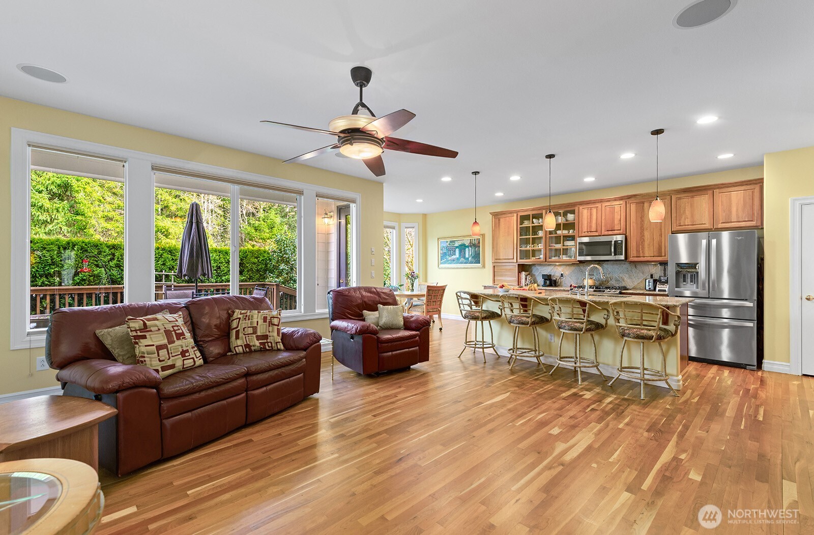 Living room features built-in ceiling speakers.   To the left of the Fireplace is a built-in Desk with Drawers.