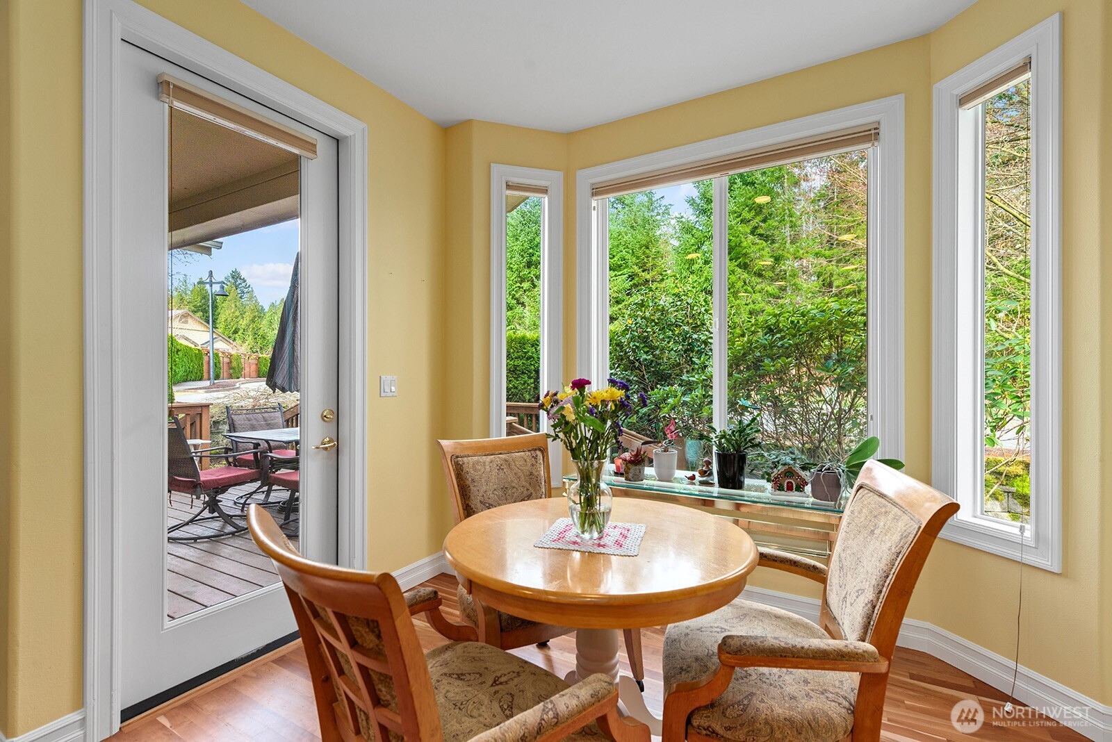 Informal dining Nook off the Kitchen surrounded by large Windows & Glass Door to the Deck.