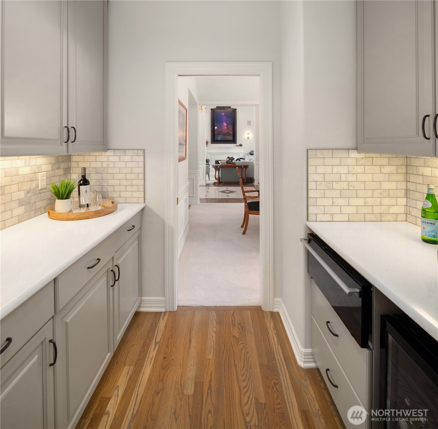 The butler’s pantry is smartly positioned between kitchen and formal dining, featuring quartz counters, a warming drawer, and wine cooler.