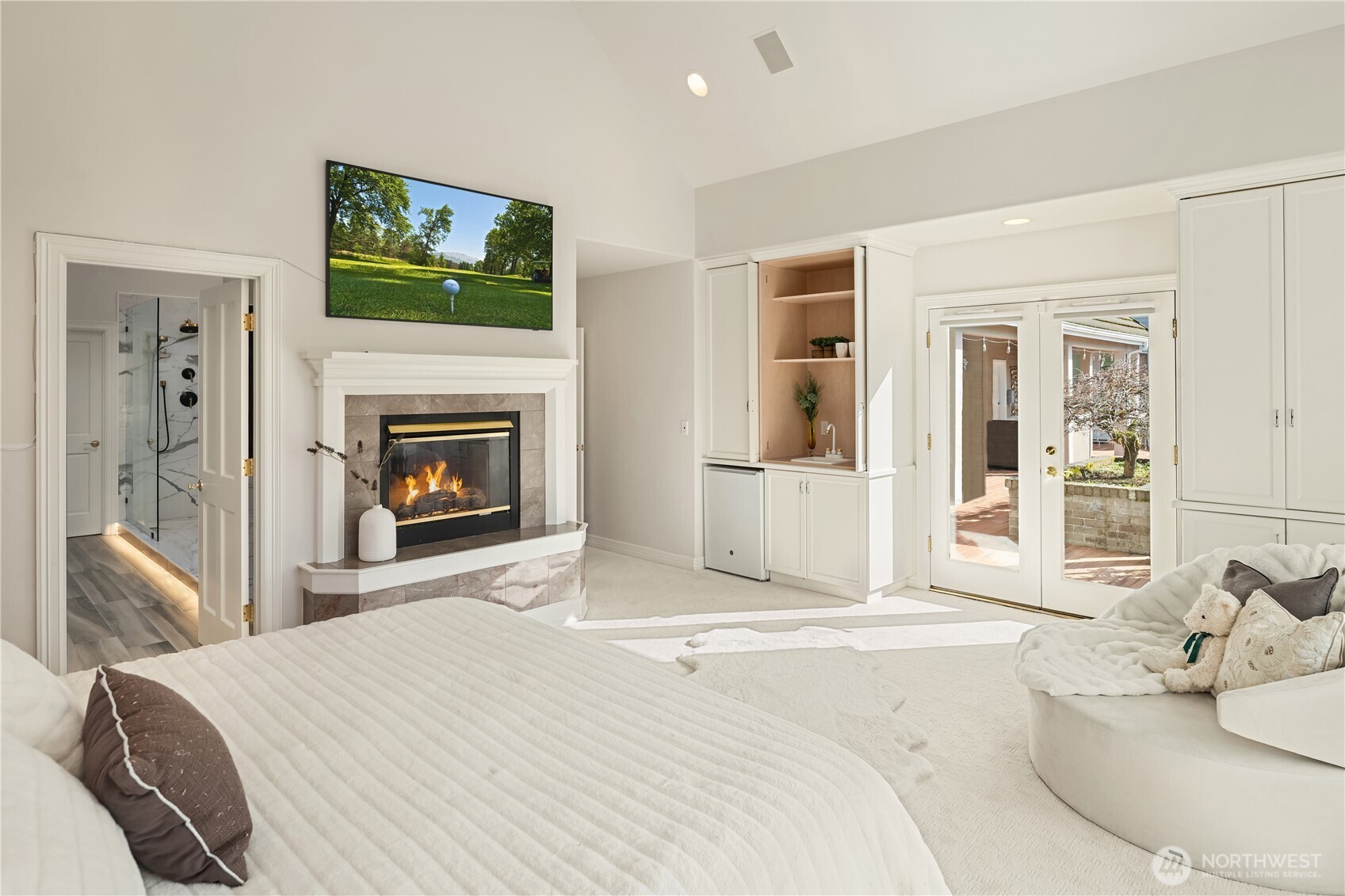 The main-level primary suite soars with natural light and features one of three fireplaces to keep you cozy warm throughout the year.