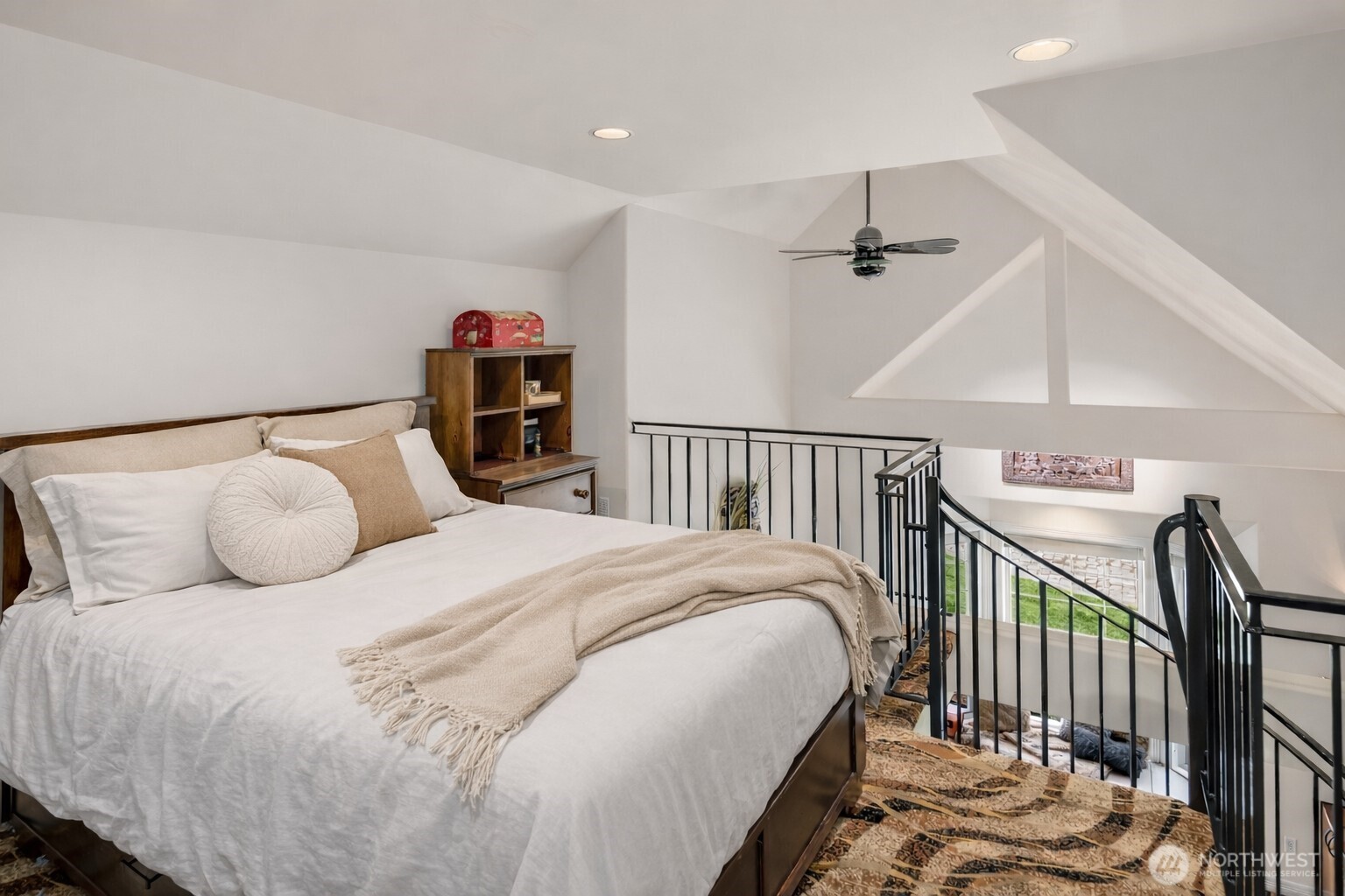 The bedroom showcases dramatic beamed, vaulted ceilings that elevate the space.