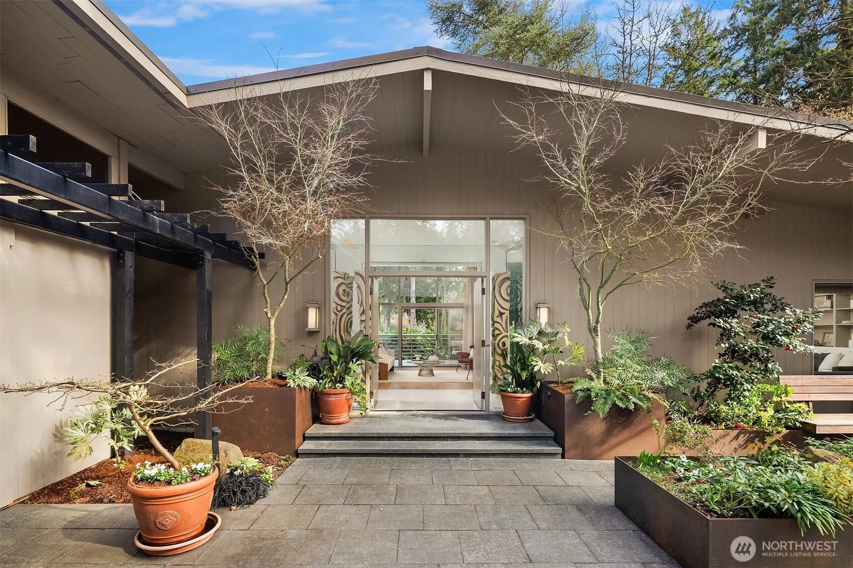 A beautiful arrival through Japanese-inspired gardens — featuring a dramatic fifteen-foot custom steel planting bed — invites you into an iconic Mid-Century Modern home inspired by the visionary legacy of Paul Hayden Kirk.