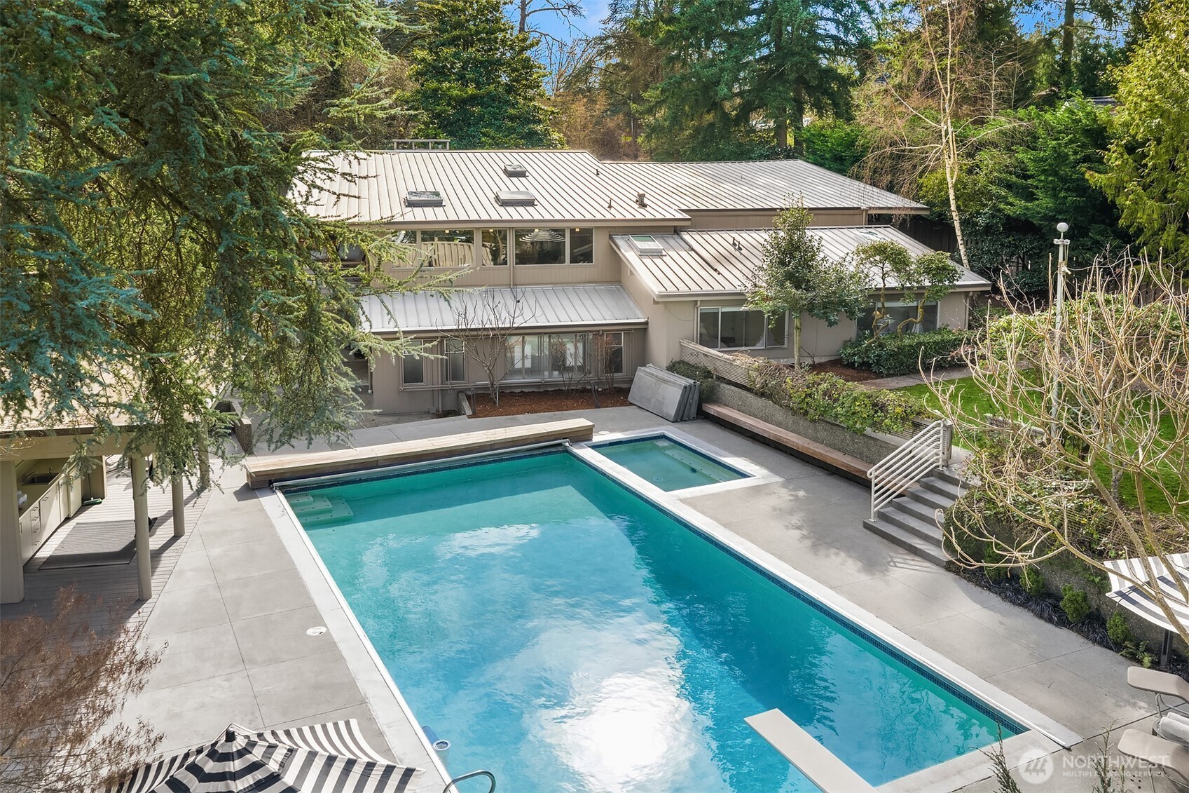 Outside, a cabana, pool, hot tub, shuffleboard, and backyard celebrate the very best of PNW living.