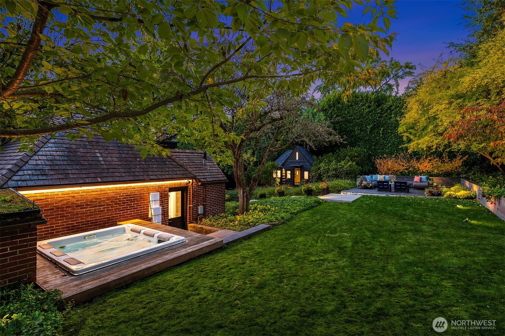 Hot tub tucked behind the garage and a flat grassy area for Fido, croquet, kid play