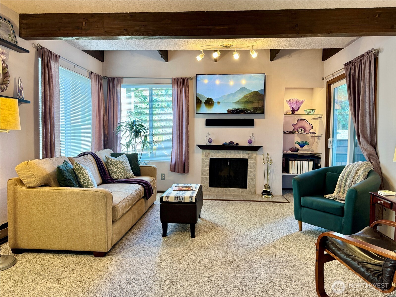 Living room with exposed beam and balcony access