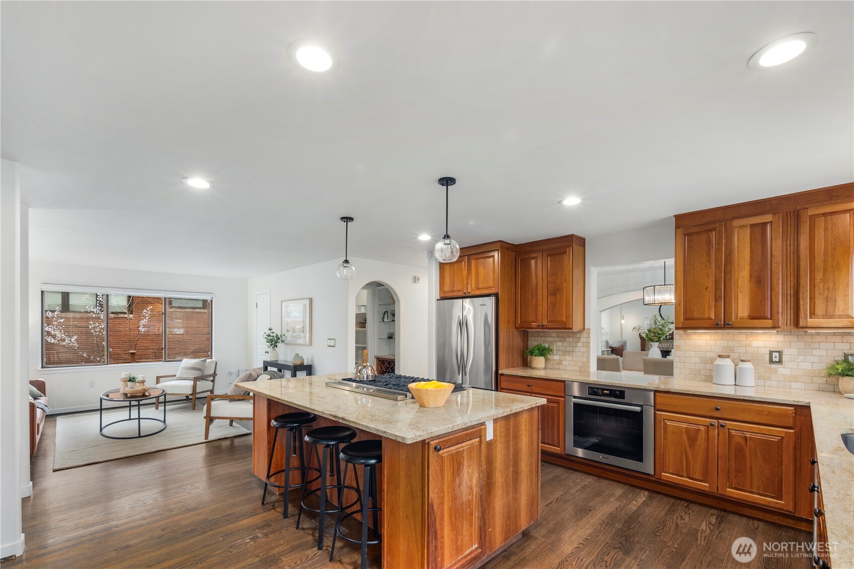Spacious kitchen featuring a large island with seating, abundant storage, and a convenient pass-through to the dining room, ideal for effortless entertaining.