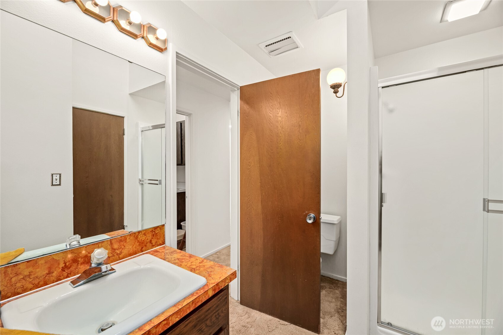 Hall continental bathroom with single vanity, shower & vaulted   ceilings. Newly painted.