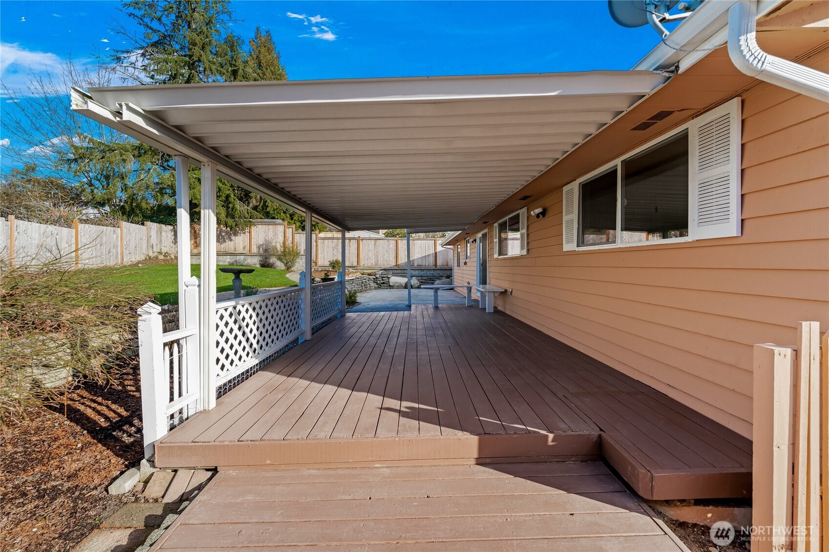 Backyard features two patios, including one covered; the wood deck, railing, and built-in bench were freshly painted, and the entry steps have been upgraded