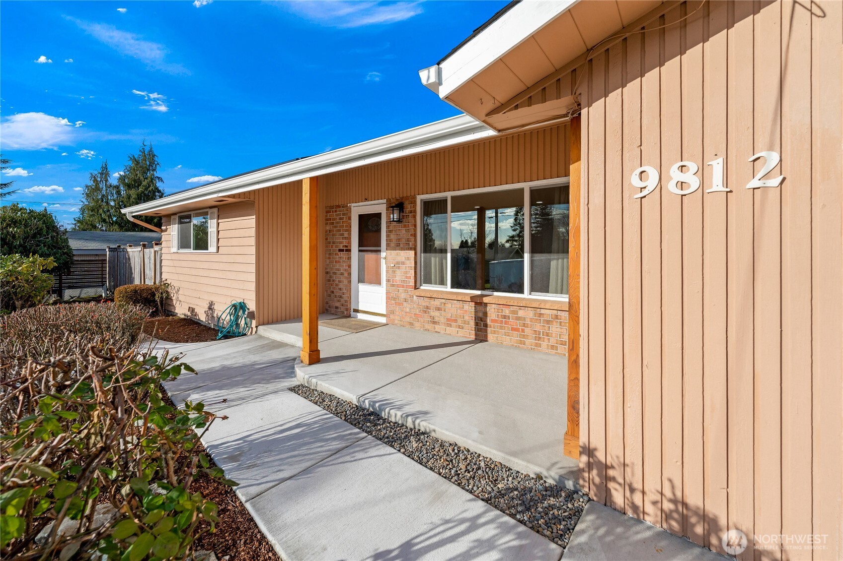 Brand-new front porch and walkway highlighted by new cedar columns and newly poured concrete, creating a warm and inviting entry