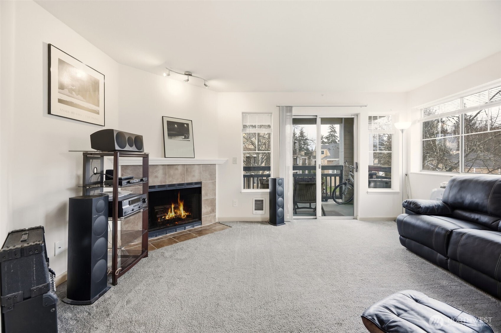 Spacious living room with lots of windows, a slider to the covered porch and a cozy wood burning fireplace.
