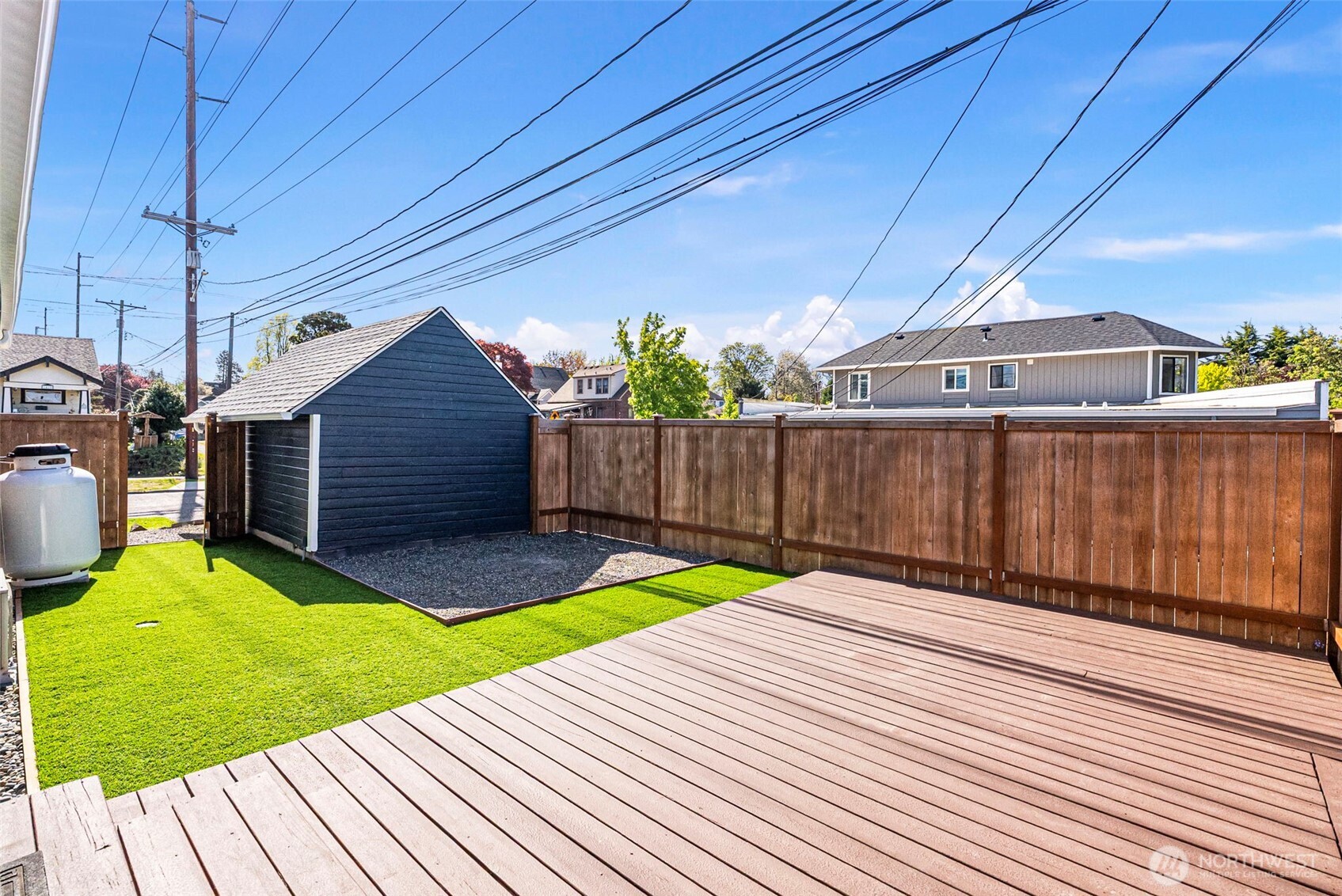 Private, fully fenced yard with artificial turf, a well maintained deck and appointed space for a fire pit.