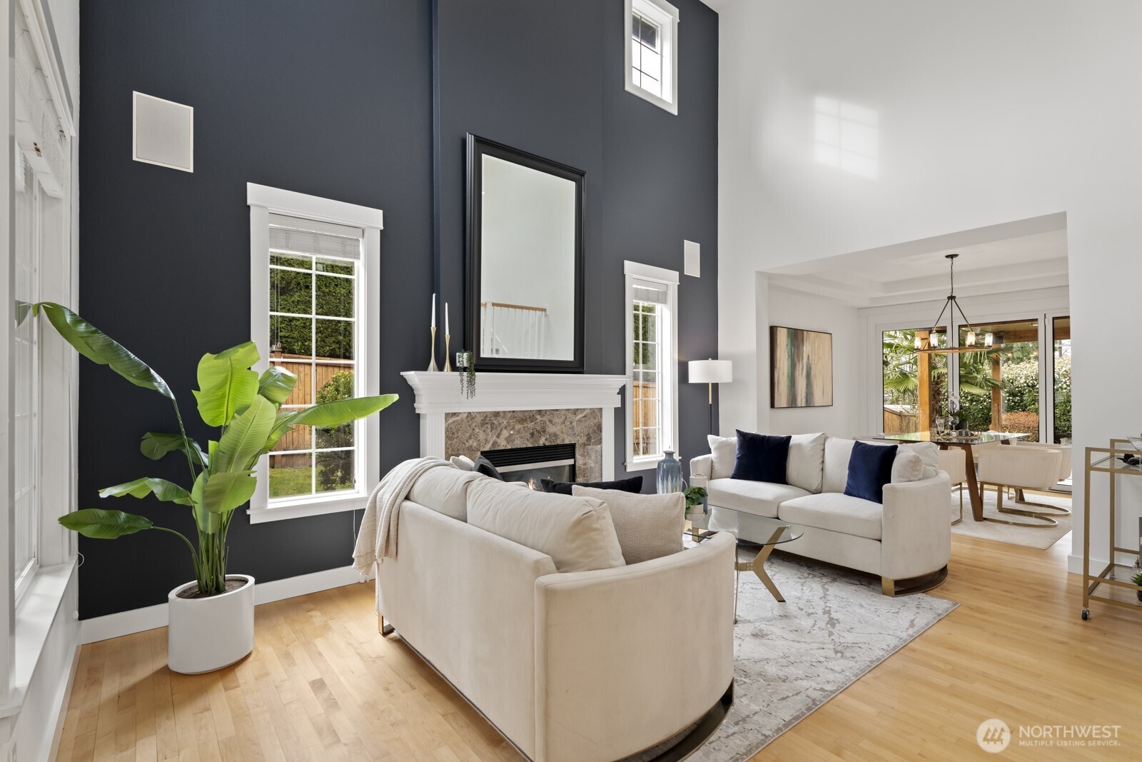 The living room is spacious and bright, with a cozy fireplace, hardwood floors, and a stylish accent wall.