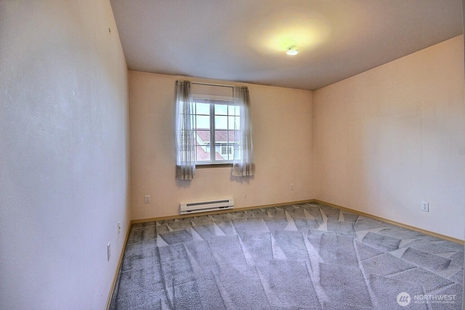 A well-sized third bedroom featuring ample natural light, a new baseboard heater and overlooks the front entry of the house.