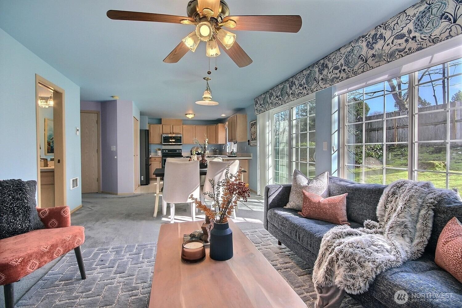 Custom window treatments and electric remote controlled blinds flank the wall of windows.