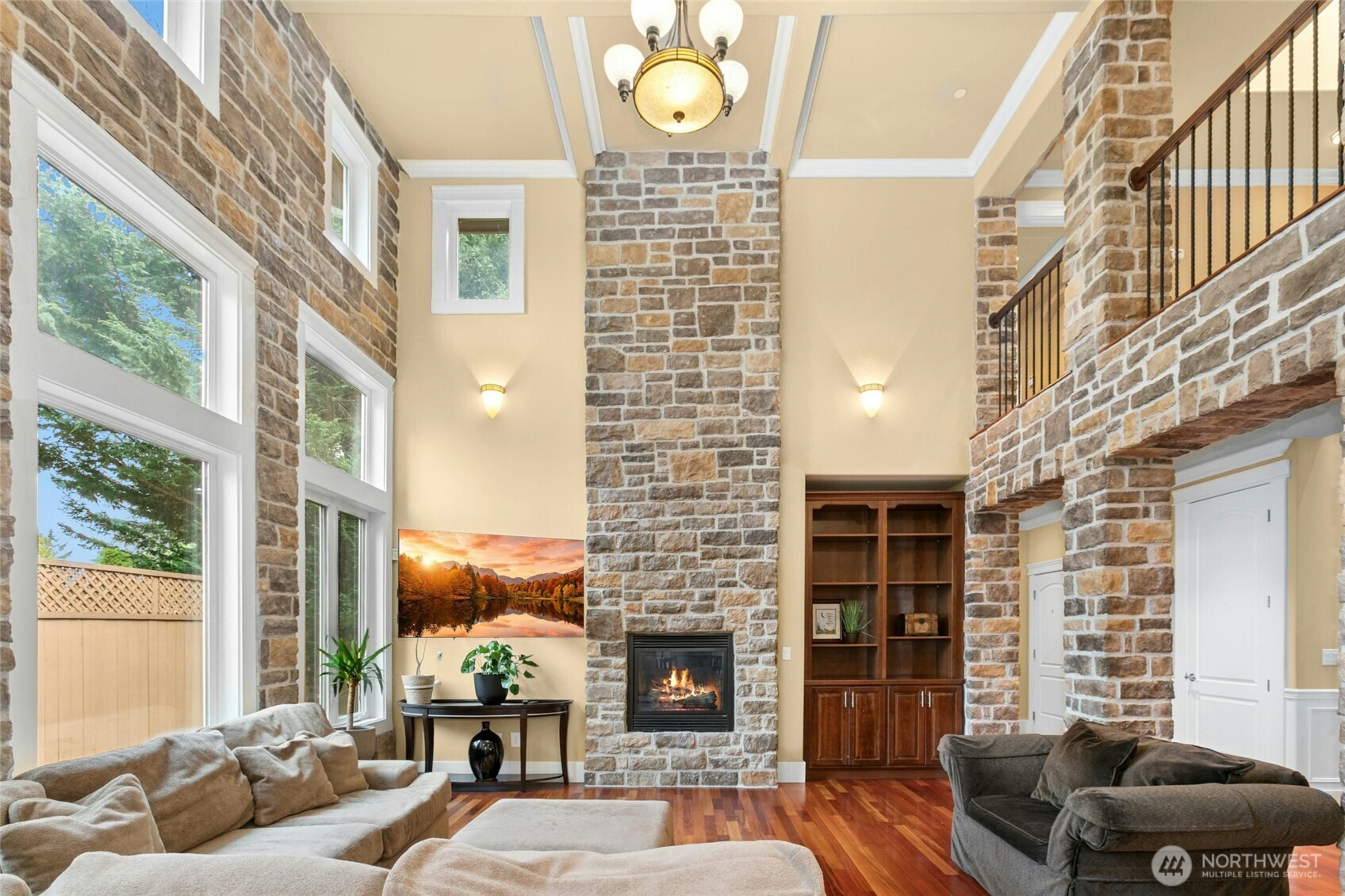 Impressive floor-to-ceiling genuine stone fireplace showcased by soaring 18-foot ceilings, creating a dramatic focal point.