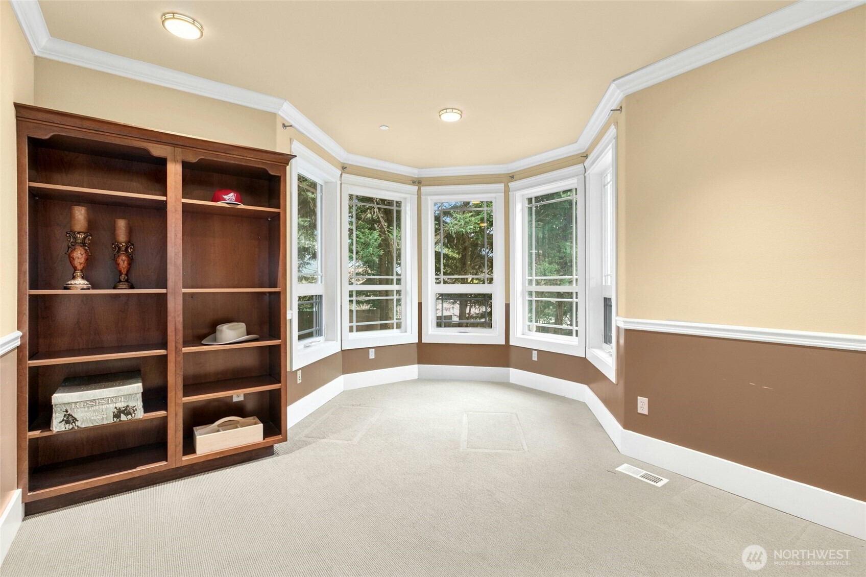 Elegant main-floor den or private office with custom built-ins and expansive windows that fill the space with natural light.