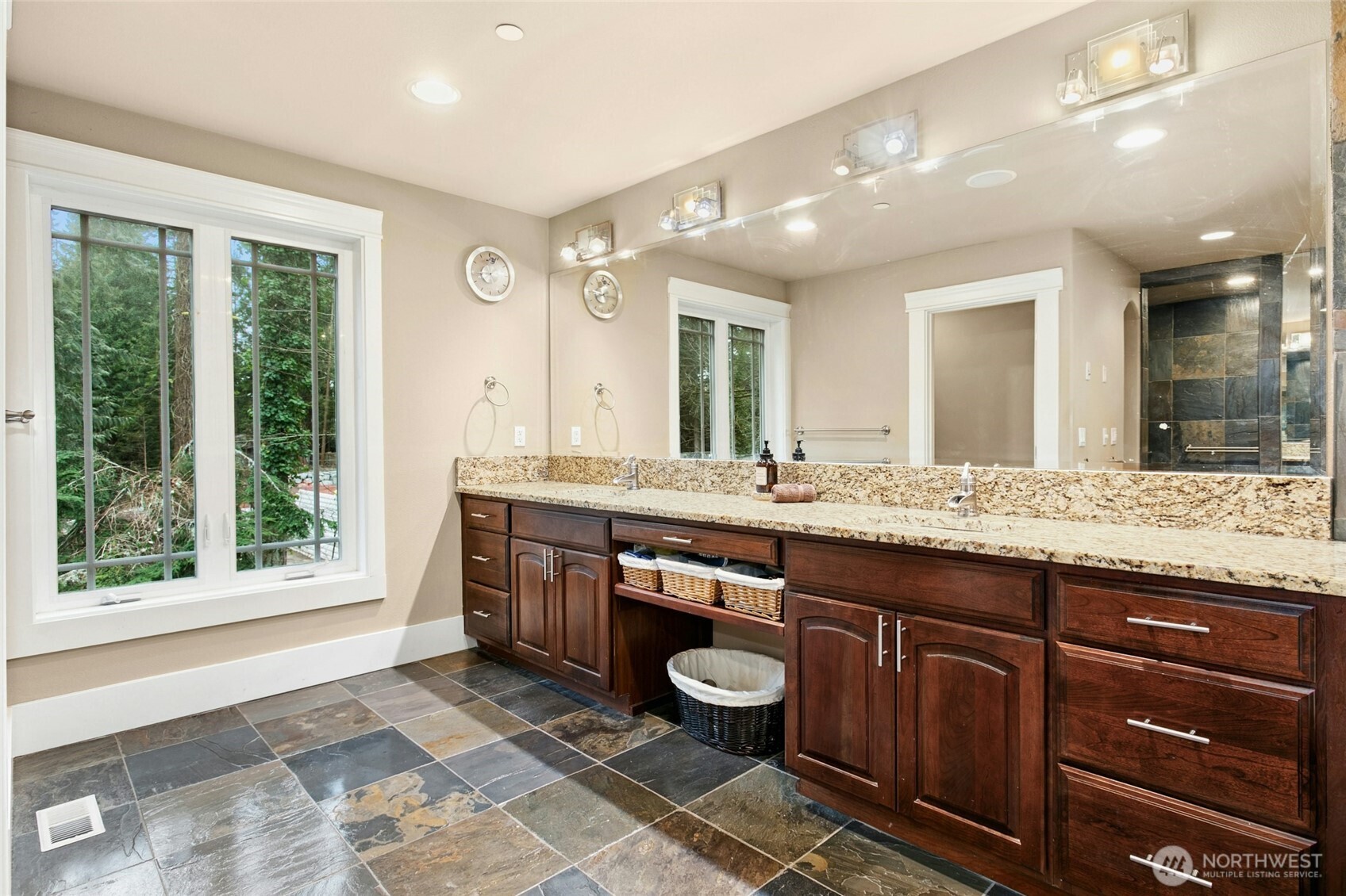 Elegant primary bathroom offering dual vanities and generous custom cabinetry for exceptional storage.