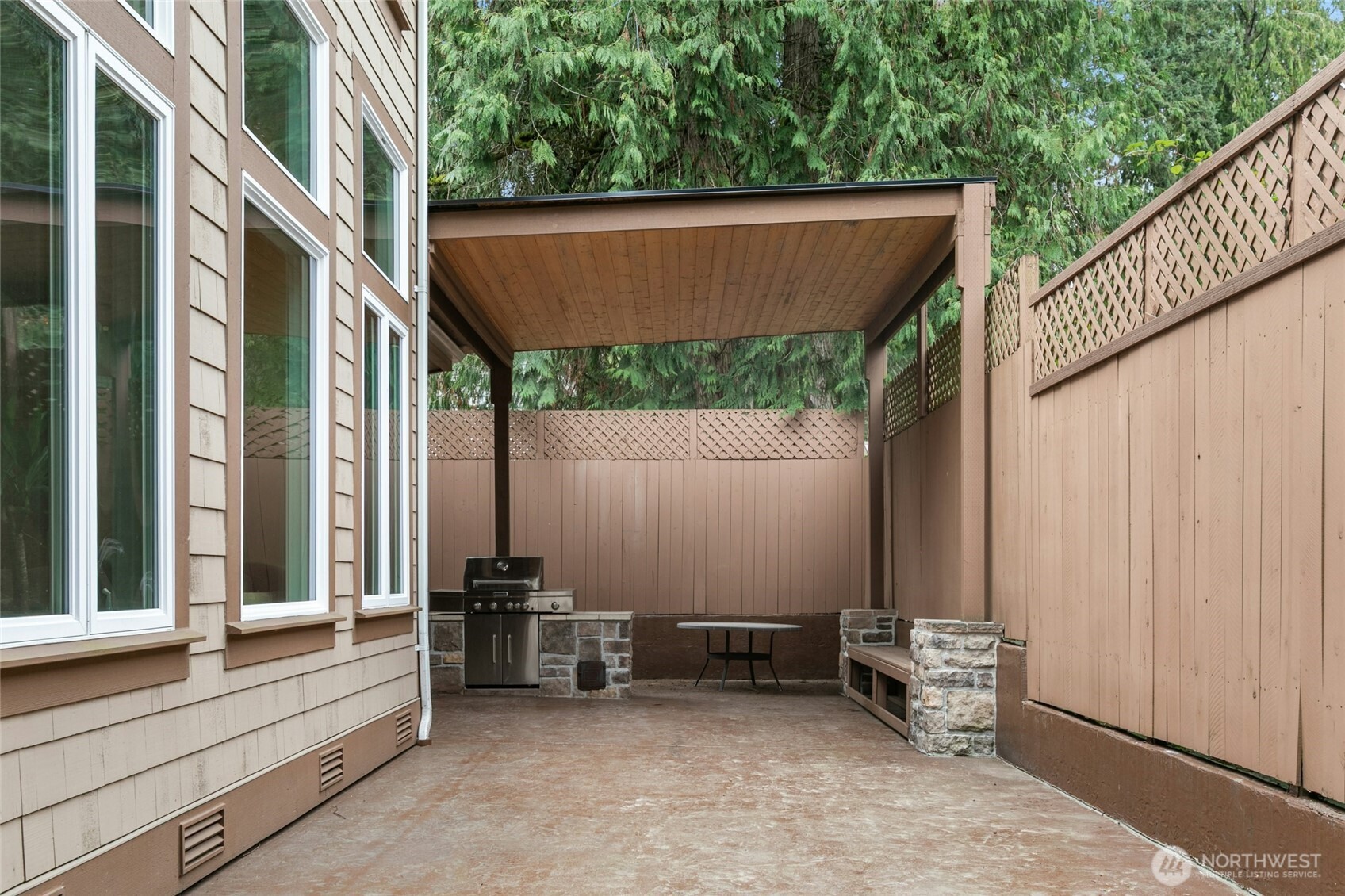 Spacious backyard patio with built-in gas grill and custom bench seating—perfect for entertaining.