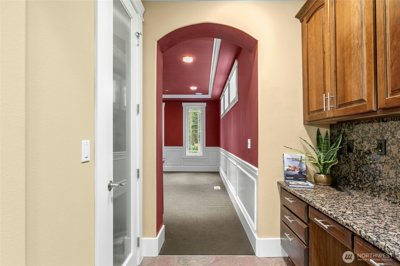 Spacious dining room adjacent to the kitchen, featuring a built-in computer desk and custom cabinetry, with convenient access to a walk-in pantry through the left-side door.