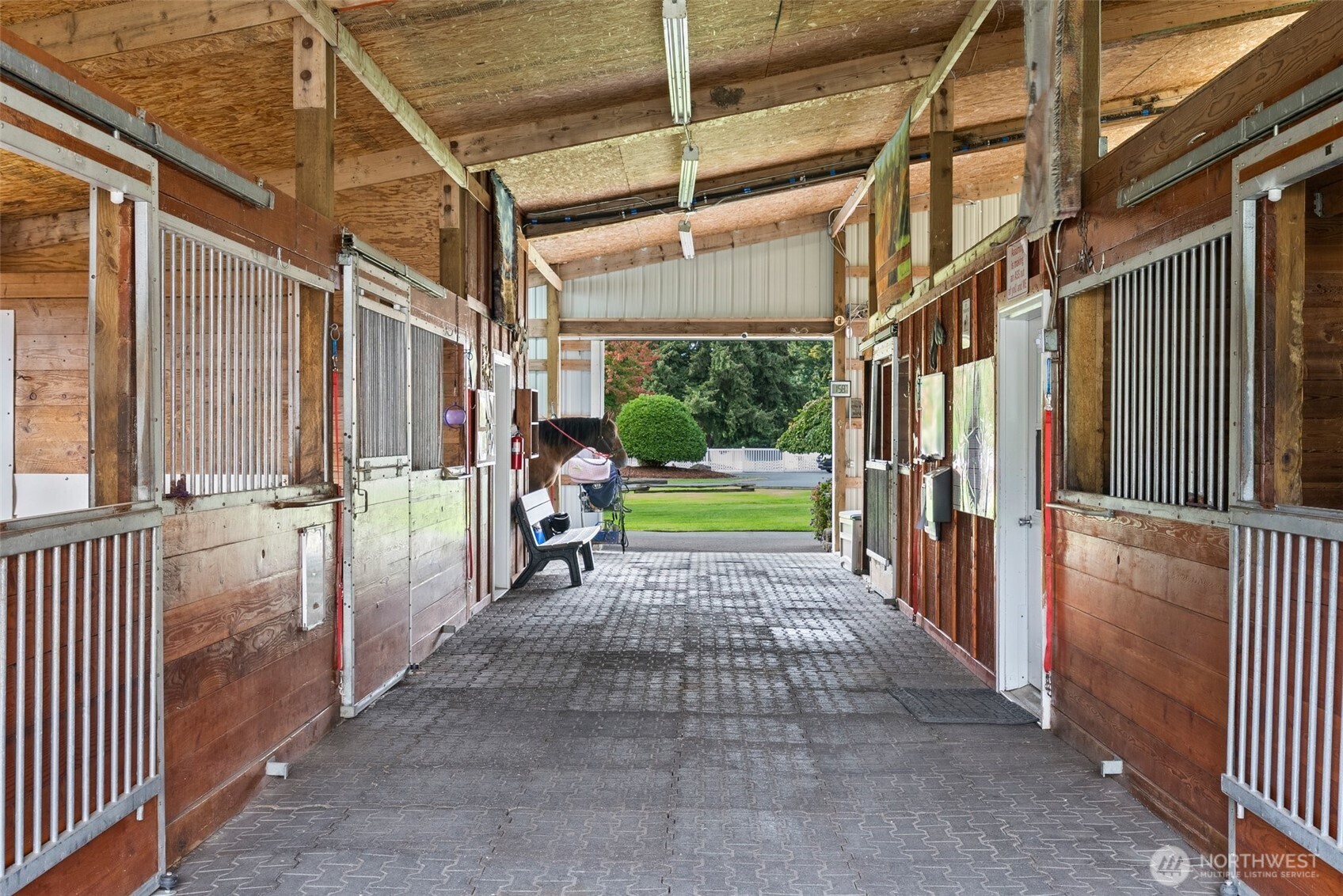 The stable showcases exceptional quality throughout, beginning with the T&G fronts and center walls in each stall, offering both durability and a polished aesthetic. Drop-down stall fronts and easy-glide doors for seamless access. The aisle is lined with rubber pavers, creating a cushioned surface for safe, comfortable walking, enhancing both safety and comfort for horses and handler.
