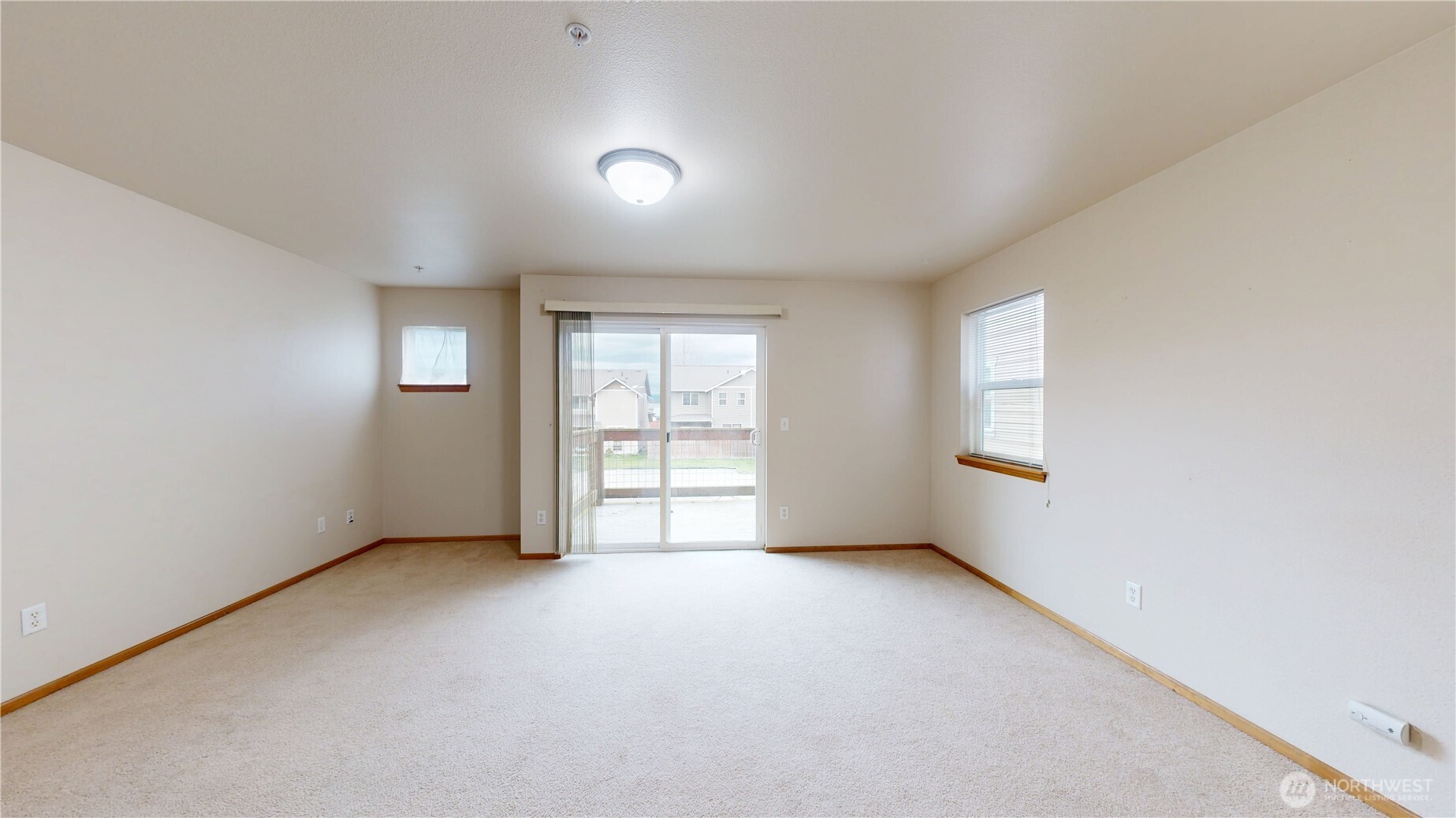 Living room view to sliding glass door leading to the deck.